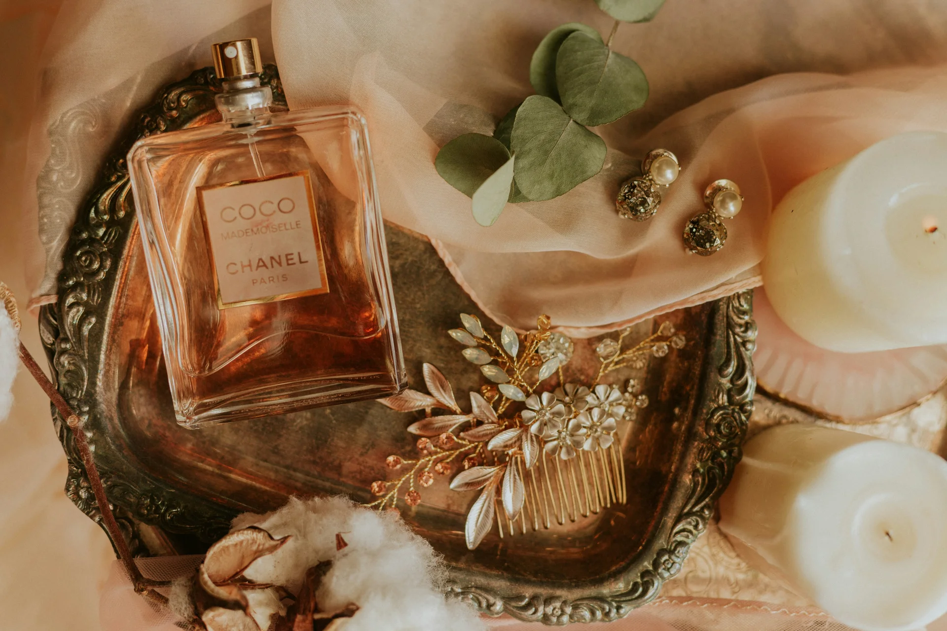 Chanel Coco Mademoiselle perfume arranged on an ornate tray with silk, jewellery and candles